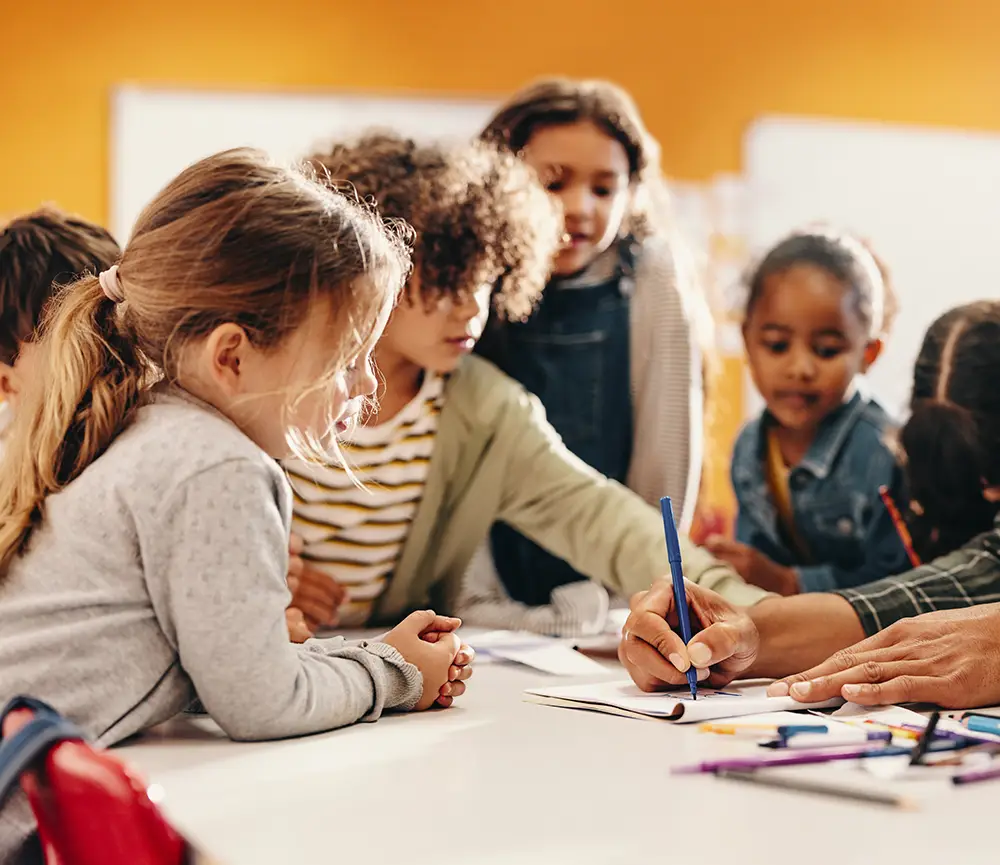 Find Programs. Children working at table.